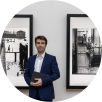 Artify - Portrait du cofondateur Simon Cau devant deux tableaux d'art connectés diffusant des oeuvres de Willy Ronis