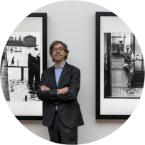 Artify - Portrait du cofondateur Christophe Roux devant deux tableaux d'art connectés diffusant des oeuvres de Willy Ronis
