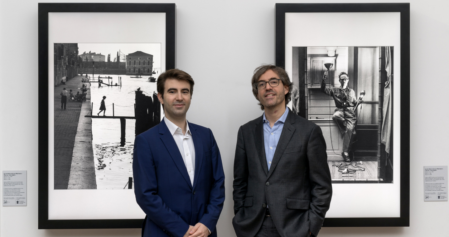 Artify - Portrait des deux cofondateurs Simon Cau et Christophe Roux devant deux tableaux d'art connectés diffusant des oeuvres de Willy Ronis