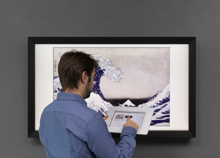 Artify - Cofondateur Simon Cau sur la tablette de médiation devant un tableau d'art connecté